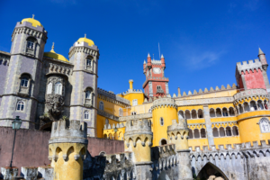 This travel guide to Lisbon includes suggestions for easy day trips outside of the city. One day trip includes the front entrance of the colorful Palácio da Pena.