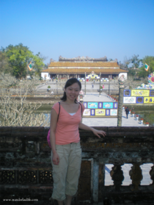 Me, a fellow traveler, standing in front of a colorful temple in Vietnam.