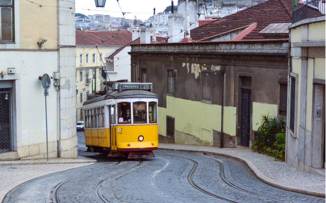 The famous Lisbon Tram making its way up a narrow and winding street.