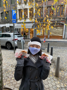 Me holding one cinnamon and one vanilla waffle across the street from Une Gaufrette Saperlipopette in Liège, Belgium.