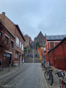 A handful of people walking up and down Montagne de Bueren in Liège on a cold and grey day.