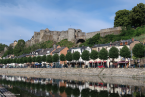 A quiet city center with the river below and Bouillon castle above.