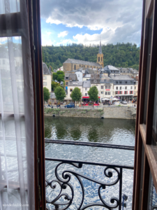 The view outside the hotel balcony door of the city center across the river.