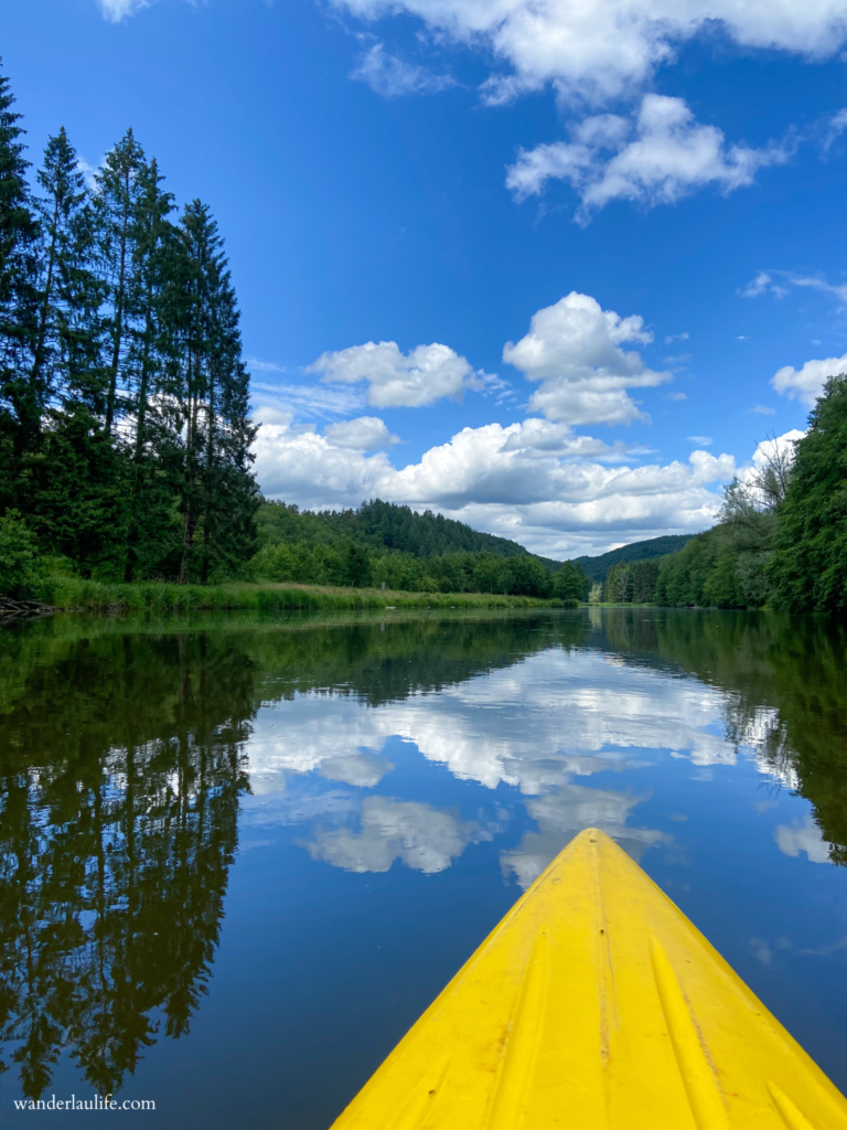 Kayaking on the Semois with still and reflecting waters.