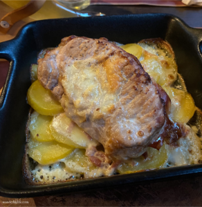 Pork served with creamy potatoes au gratin.