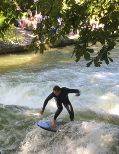 Catching a river surfer riding a wave in Munich.