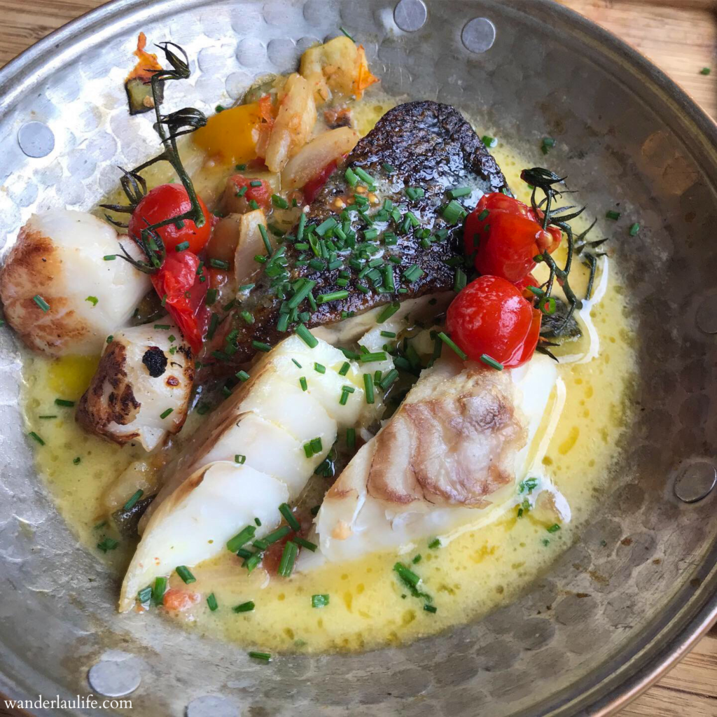 A buttery fish dish with scallops and tomatoes on the vine at La Mère Poulard.