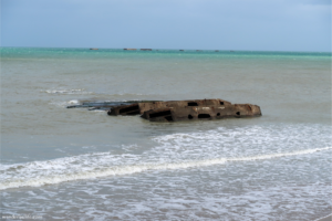 Praia Gold Beach with some war materials left behind in the water.