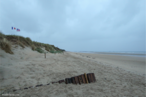 A stoic Utah Beach with the American and French flags after sunset, one of the D-Day Sites on our itinerary.