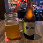 A glass of beer next to it’s Bruder bottle, one of the breweries you have to try in Bogotá.