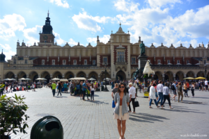 Me, standing in historic Main Market Square with tourists behind me during my visit in Kraków.